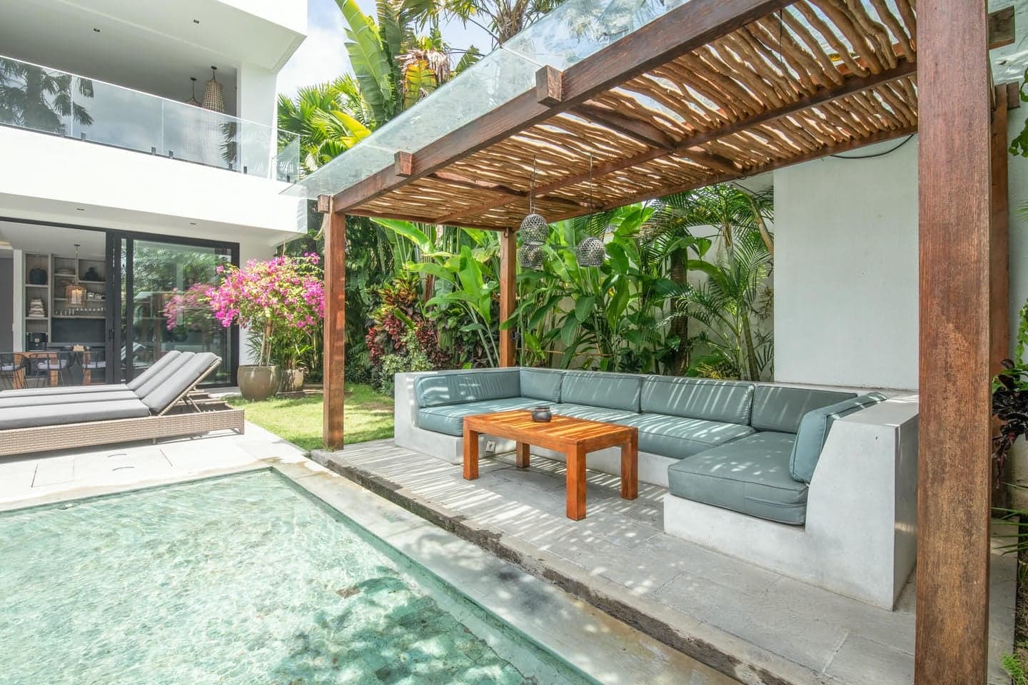 Villa Niko Dua — shaded pergola lounge at the water's edge