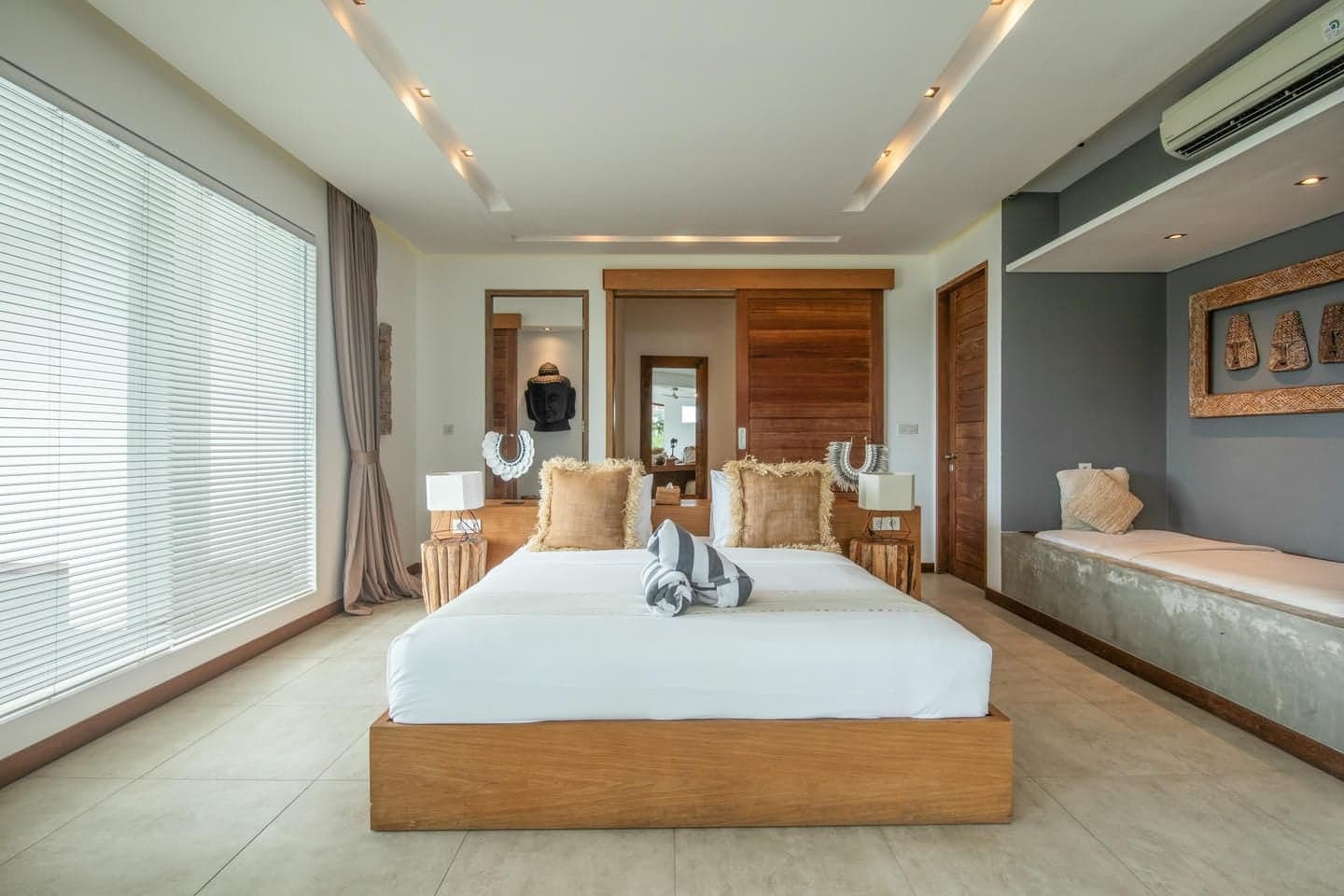 Villa Niko Dua — upstairs bedroom with wooden headboard wall